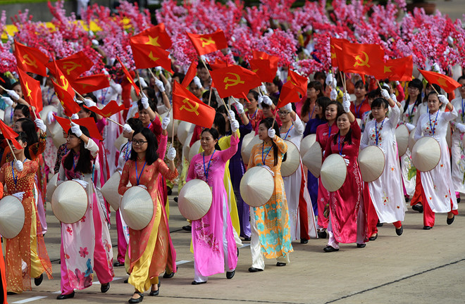 vietnamese women in national parade proudly holding vietnam's national flag