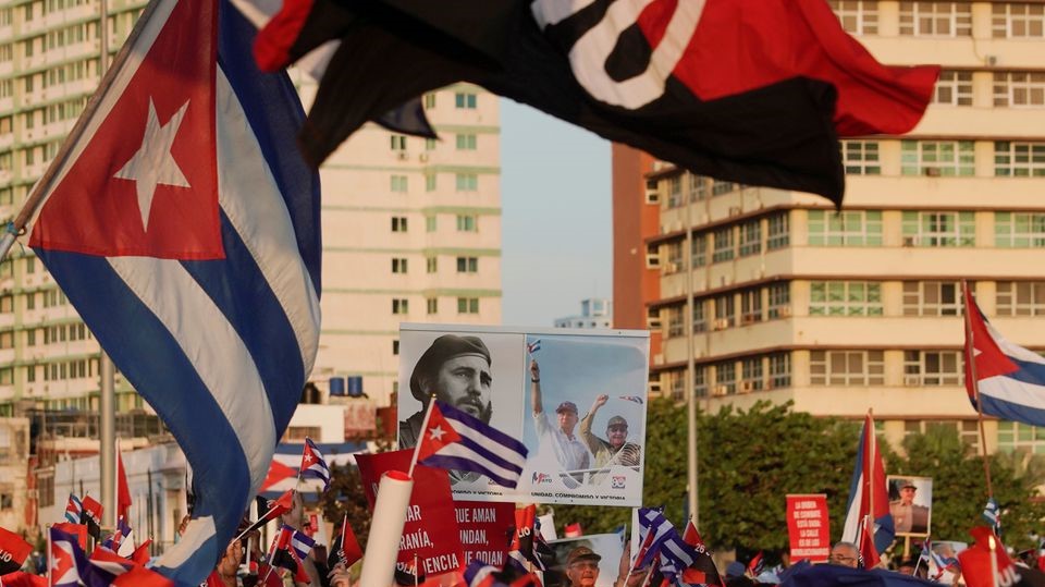 People carry a poster with photographs of Cuba's late President Fidel Castro, Cuba's President and First Secretary of the Communist Party Miguel Diaz-Canel and Cuba's former President and First Secretary of the Communist Party Raul Castro during a rally in Havana, Cuba, July 17, 2021.